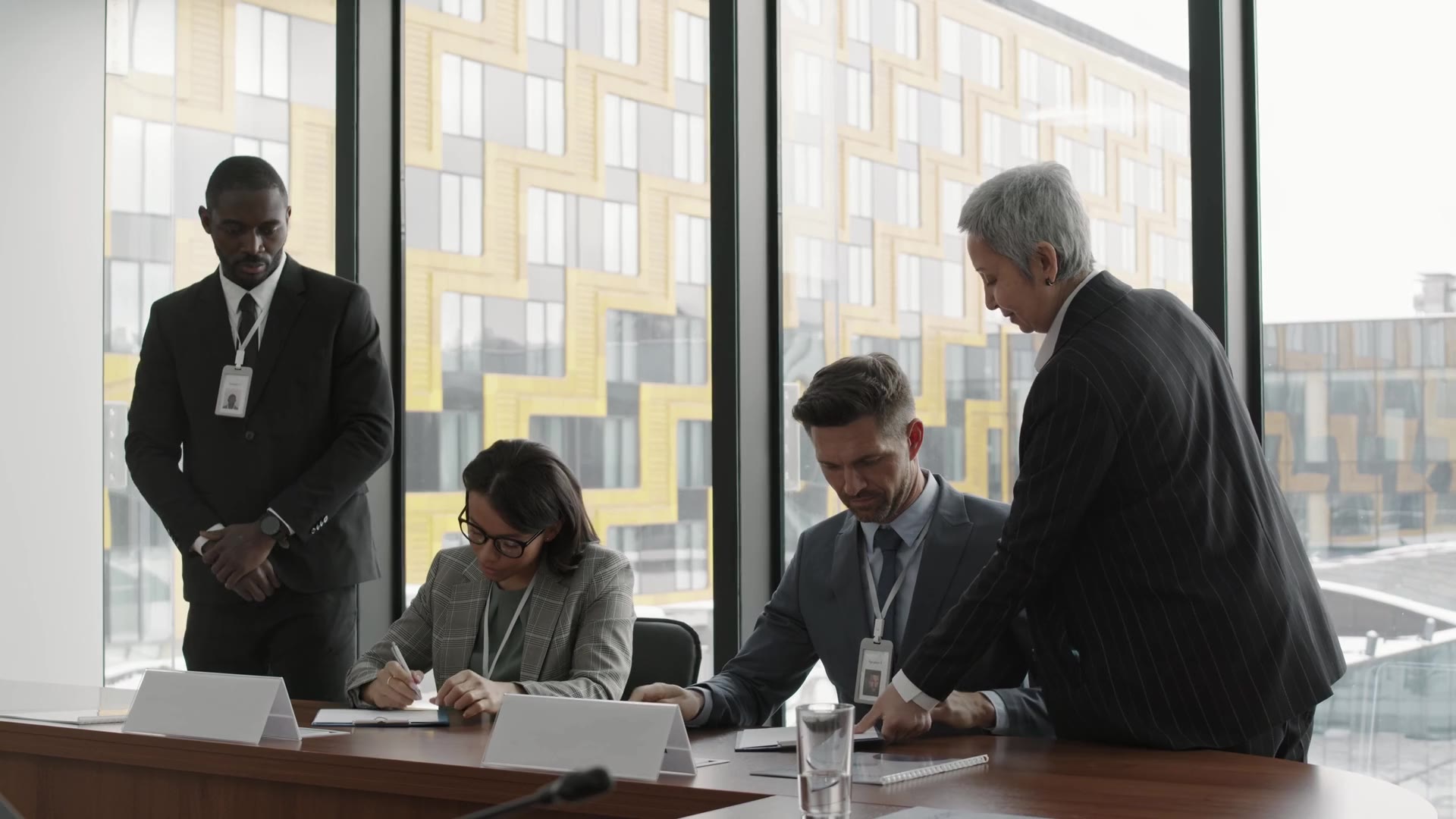 Business professionals signing a partnership agreement at a conference table